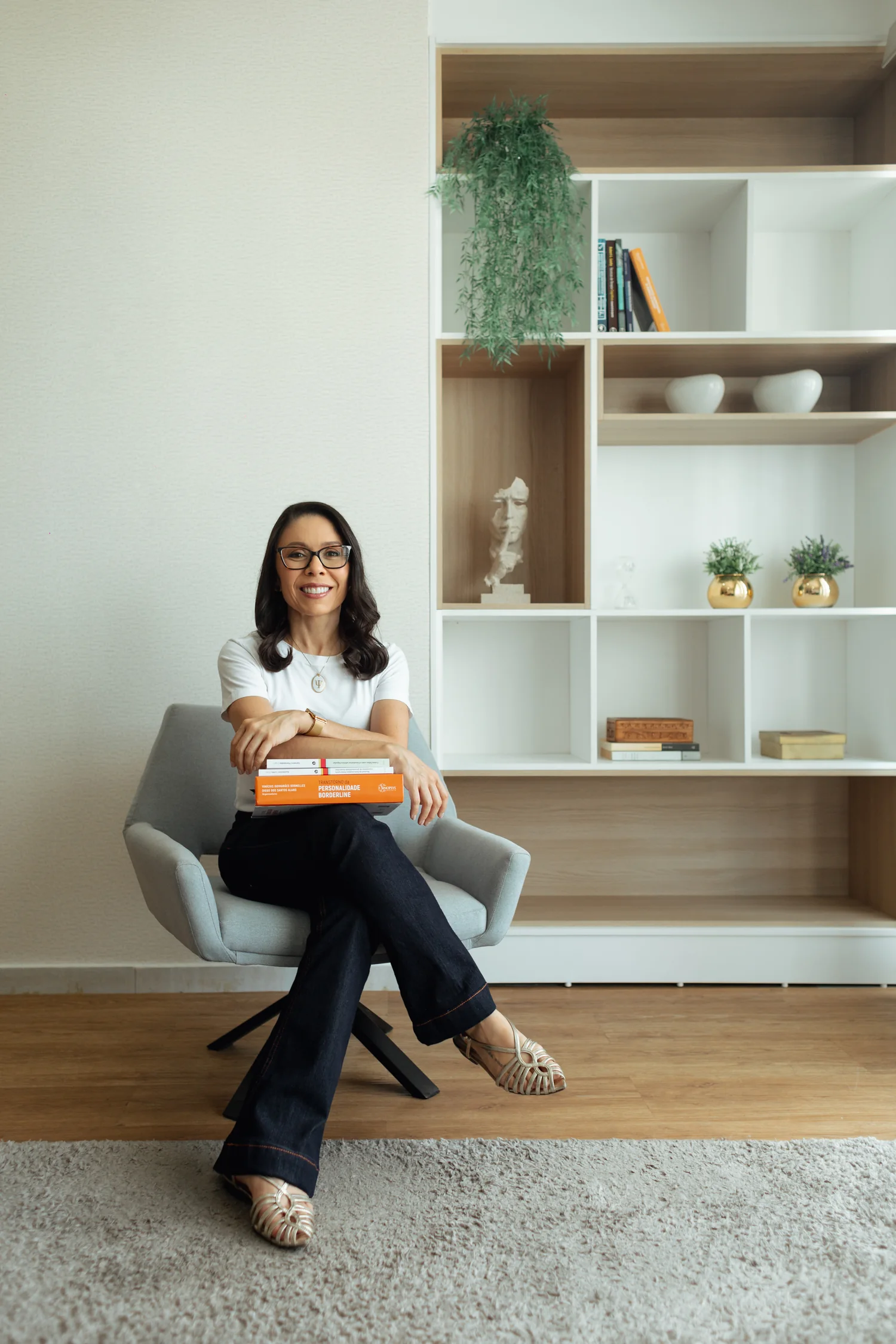 Silvia Morais no consultório com livros sobre Psicologia